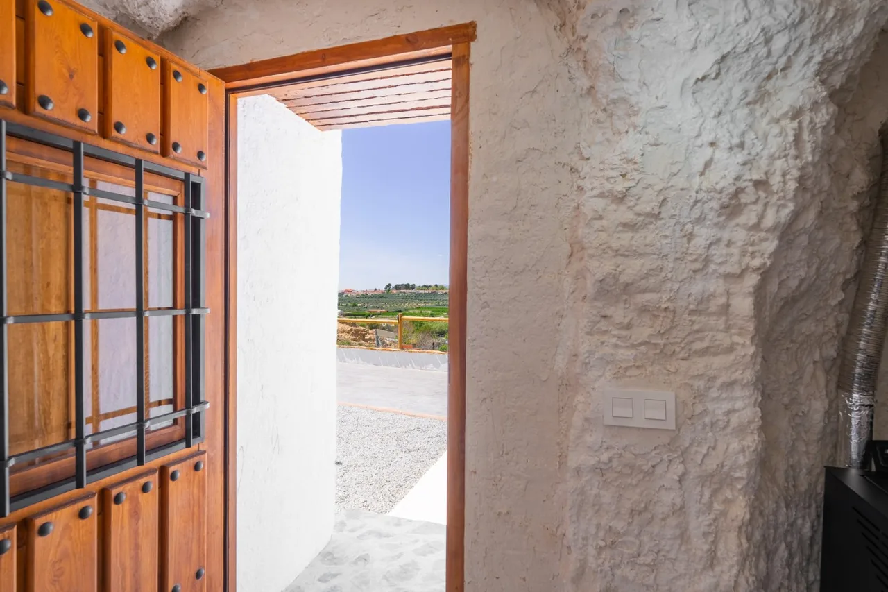 Open timber door from Cueva Alba to the outdoor terrace